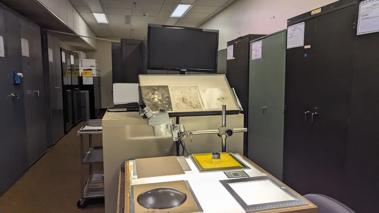 میزی با سطح نورانی در اتاقی پر از کابینتهای بایگانی قرار دارد