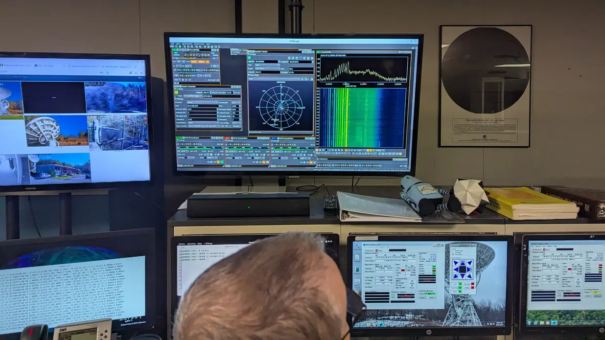 مردی در یک ساختمان صنعتی پشت ردیفی از کامپیوترها نشسته است