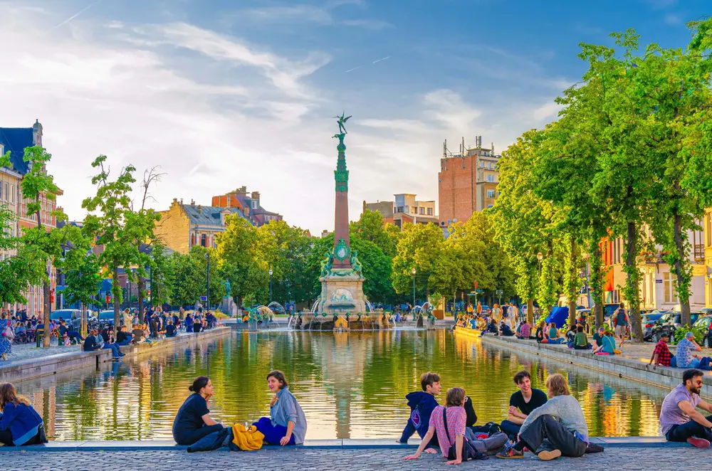 گردشگران جوان در کنار فوارهٔ کوچک فونتین آنسپاخ در میدان Vismarkt، بازار ماهی‌فروشی بندر قدیم، مرکز تاریخی شهر بروکسل