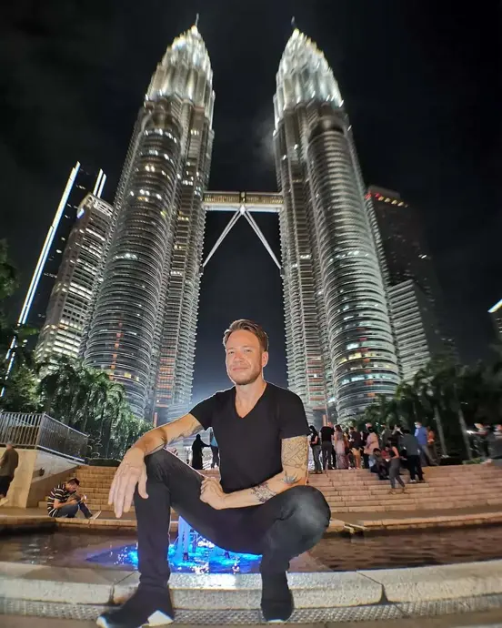 آندره نویلینگ در حال عکسبرداری در خارج از برج پتروناس در کوالالومپور، مالزی.