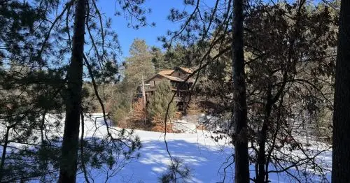 رستورانی در یک کلبه چوبی پشت دریاچهٔ برفی در جنگل.