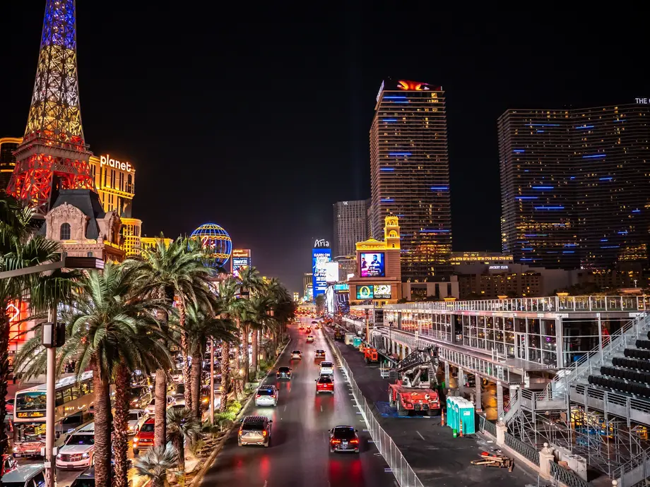 نمایی از پهن‌راه لاس‌وگاس در شب، با ساختمان‌های روشن و خودروهایی که در خیابان‌ها می‌چرخند.