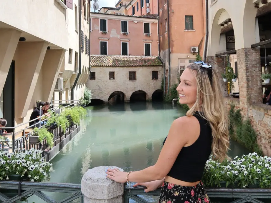 کلوی در کنار کانالی که توسط ساختمانها و گلها احاطه شده است.