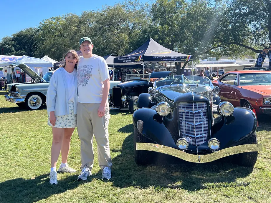 نویسنده و همسرش که در کنار خودرویی شبیه عتیقه عکاسی می‌کنند.