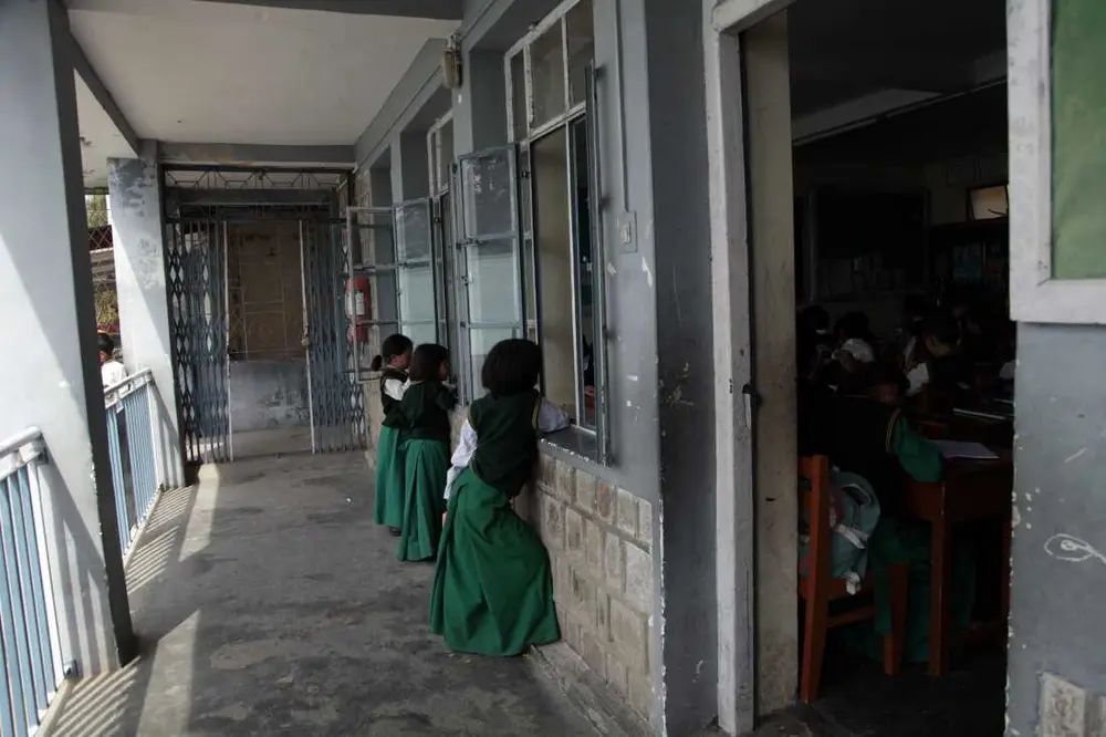 دانش‌آموزان از پنجره‌های کلاس درس در مدرسه کودکان تبت در دارامشالا، شهری کوهستانی و مرتفع در هیمالیای شمالی هند که پایتخت غیررسمی تبتی‌های در تبعید است، با یکدیگر صحبت می‌کنند. تعداد کودکان این مدرسه در حال کاهش است که سرنوشت خود جامعه تبعیدی را بازتاب می‌دهد. عکس از ضیاء حدید، دارامشالا، آوریل ۲۰۲۵