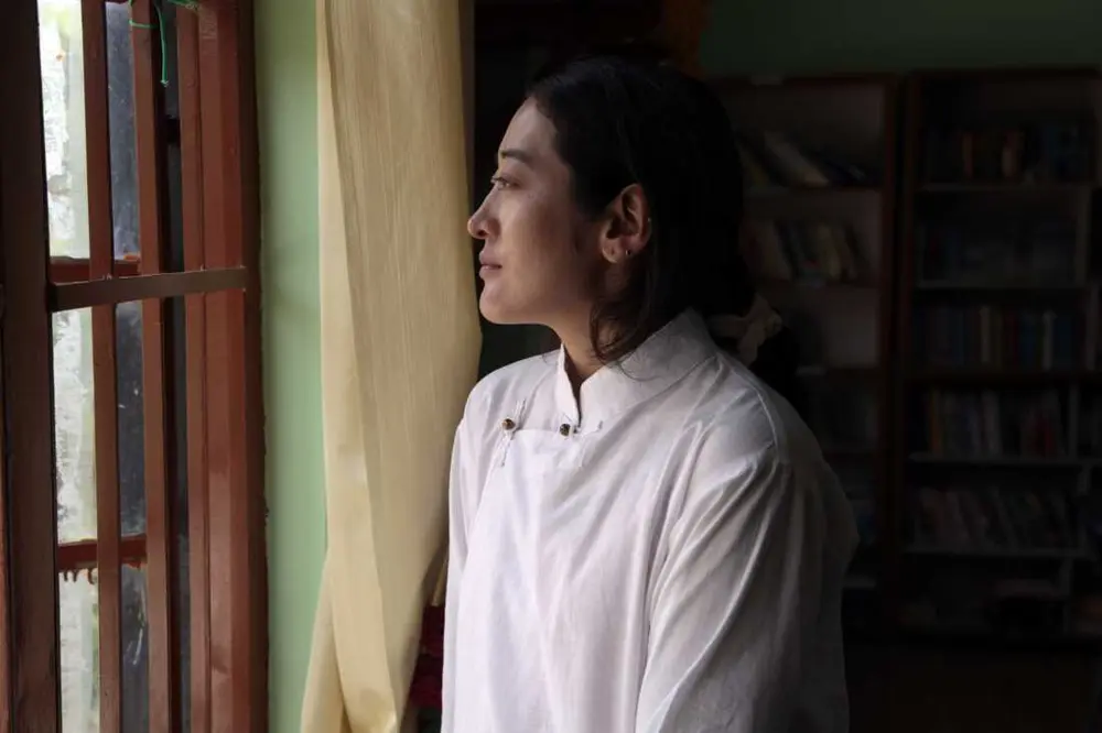 یکی از تبتی‌هایی که پس از سخت‌گیری مقامات چینی در مرز در سال ۲۰۰۸ موفق شد خود را به دارامشالا برساند، نامکی ۲۷ ساله است که تنها یک نام دارد. او می‌گوید ۹ سال طول کشید تا افراد مناسب را برای قاچاق او به خارج از چین پیدا کند. او از زمانی که از یک اردوگاه کار اجباری آزاد شد، جایی که در نوجوانی به مدت سه سال در آنجا نگهداری می‌شد، برای فرار خود نقشه می‌کشید. او می‌گوید این مجازات به خاطر به نمایش گذاشتن عکسی از دالایی لاما بود. اما او می‌گوید زندگی در دارامشالا گاهی او را غمگین می‌کند. «همه به خارج می‌روند، اینجا هیچ بچه‌ای نیست.» عکس از ضیاء حدید، دارامشالا، آوریل ۲۰۲۵