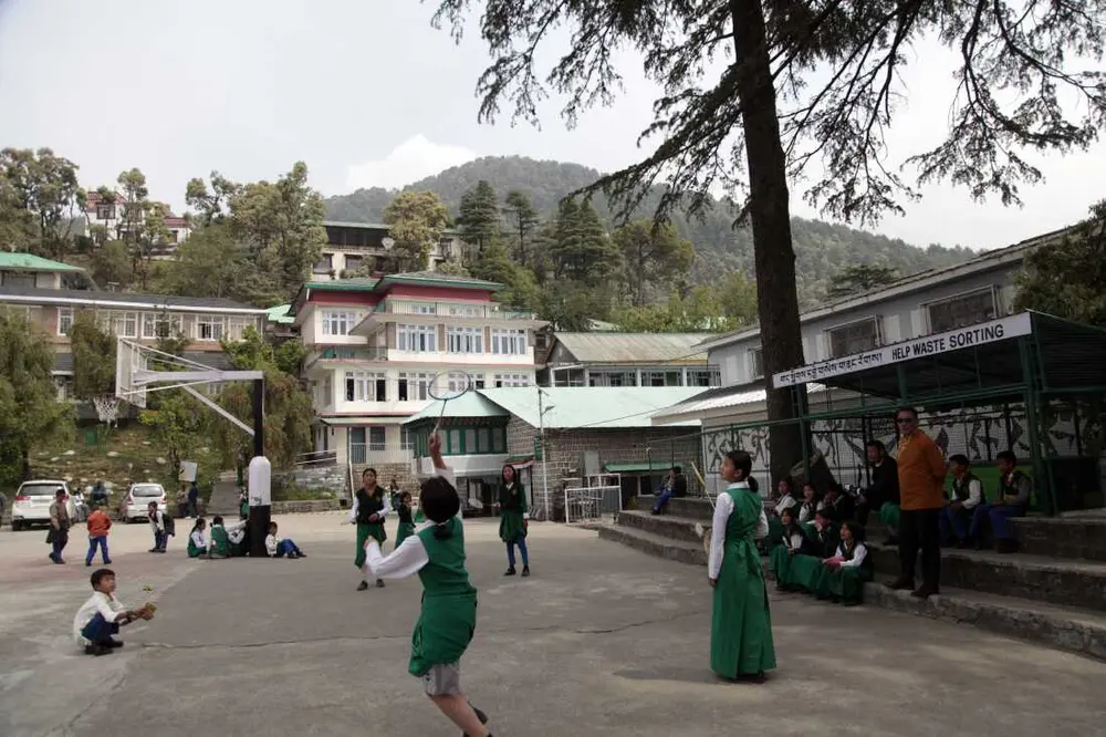 دانش‌آموزان در زمین ورزشی مدرسه کودکان تبت در دارامشالا، شهری کوهستانی و مرتفع در هیمالیای شمالی هند که پایتخت غیررسمی تبتی‌های در تبعید است، بدمینتون بازی می‌کنند. تعداد کودکان این مدرسه در حال کاهش است که سرنوشت خود جامعه تبعیدی را بازتاب می‌دهد. عکس از ضیاء حدید، دارامشالا، آوریل ۲۰۲۵