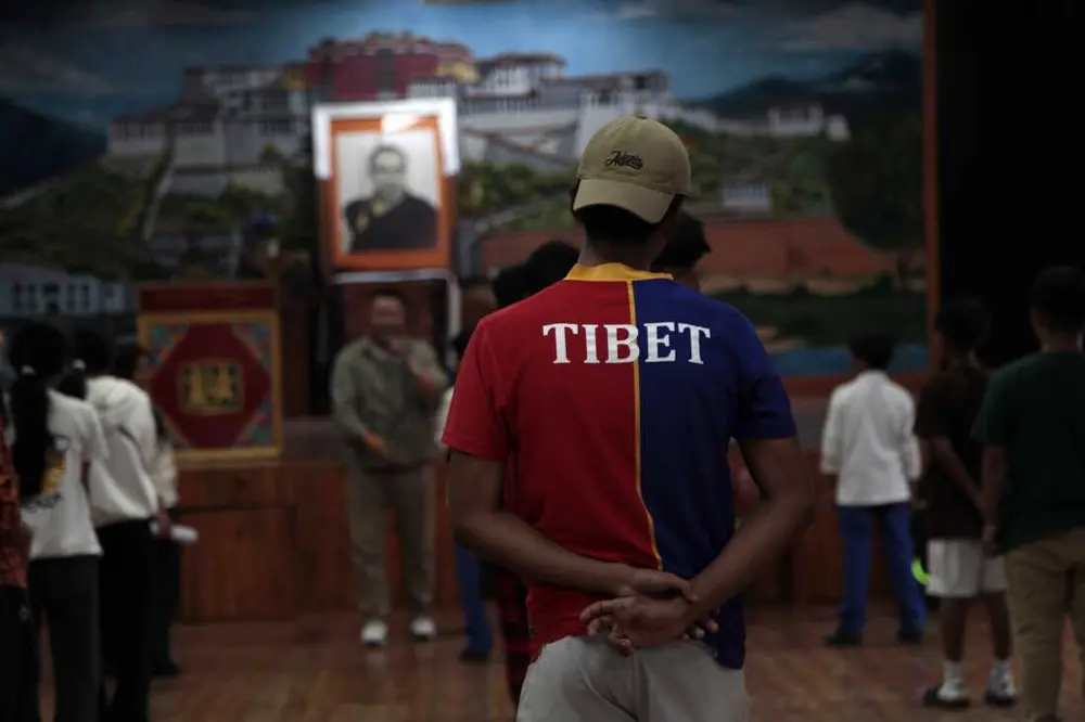 دانش‌آموزان پس از مدرسه در محوطه مدرسه کودکان تبت در دارامشالا، شهری کوهستانی و مرتفع در هیمالیای شمالی هند که پایتخت غیررسمی تبتی‌های در تبعید است، در حال تمرین یک اجرای اپرای تبتی هستند. تعداد کودکان این مدرسه در حال کاهش است که سرنوشت خود جامعه تبعیدی را بازتاب می‌دهد. عکس از ضیاء حدید، دارامشالا، آوریل ۲۰۲۵