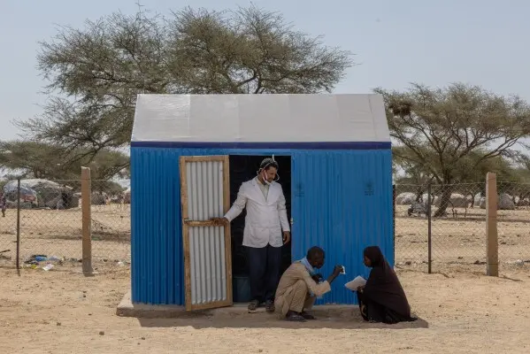 زنی را خارج از اتاق درمان یک کلینیک بهداشتی در دوآنکاره موریتانی یاری میکنند. یکشنبه، ۷ نوامبر ۲۰۲۵. (عکس آسوشیتد پرس/کیتلین کلی)