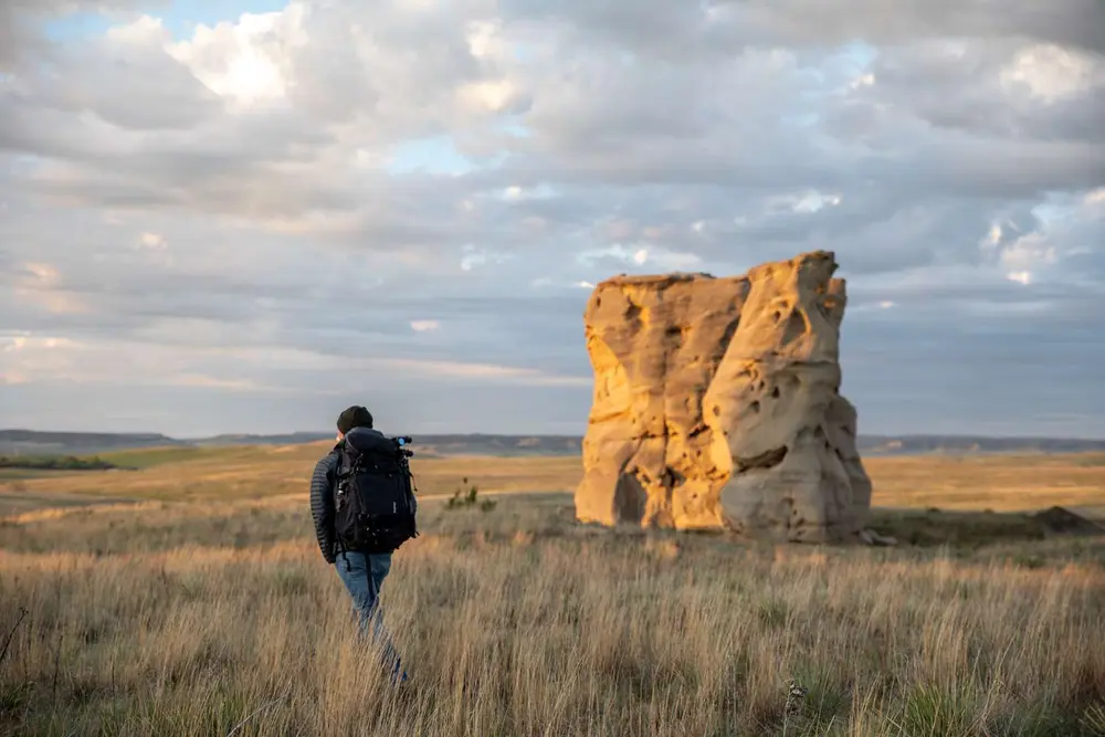 فردی که از میان یک مزرعه به سمت یک سازهٔ سنگی می‌پیماید