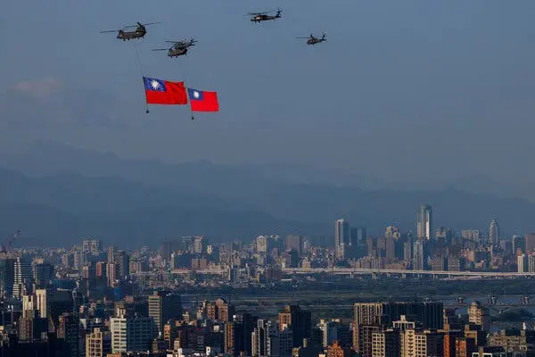 چهار هلیکاپتر بر فراز یک شهر پرواز میکنند؛ دو تا از آنها پرچمهای تایوانی را بهدنبالشان میکشند.