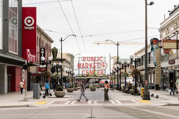 نمای بازاری عمومی و خیابانهای اطراف در شهری با تابلوهای فروشگاهها و عابران در حال عبور