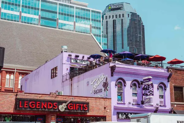 نمای خیابانی شهر با مغازهای هدیه و ساختمانی با پاسیوی پشتبام